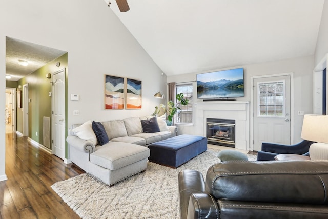 living room with dark wood-type flooring and high vaulted ceiling