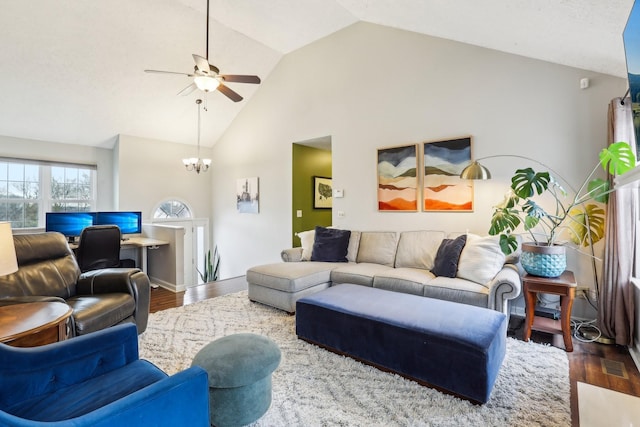 living room featuring dark hardwood / wood-style flooring, ceiling fan with notable chandelier, and high vaulted ceiling