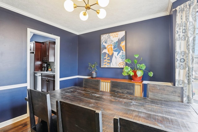 dining space with a textured ceiling, ornamental molding, and a chandelier