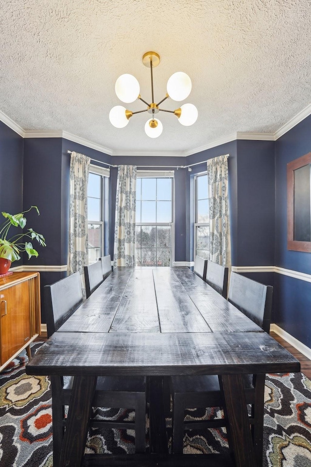 dining room featuring ornamental molding, hardwood / wood-style floors, a textured ceiling, and a notable chandelier