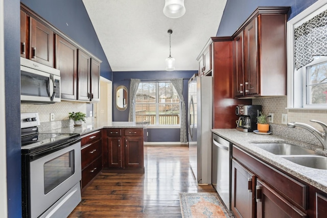 kitchen featuring lofted ceiling, sink, appliances with stainless steel finishes, dark hardwood / wood-style floors, and pendant lighting