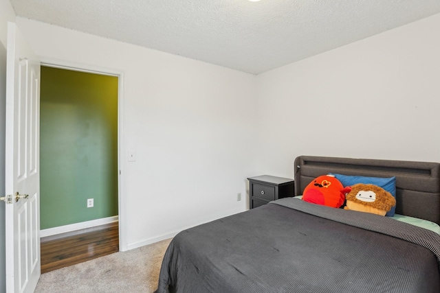 bedroom with carpet floors and a textured ceiling