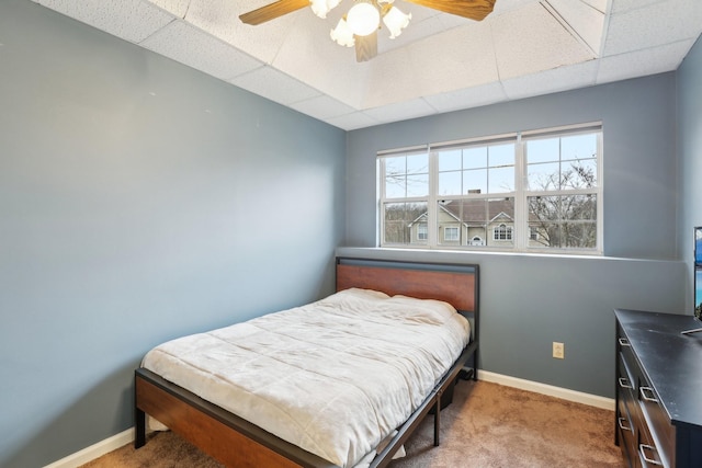 bedroom featuring ceiling fan, a paneled ceiling, and carpet flooring