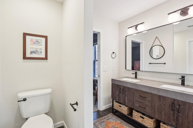 bathroom featuring vanity, hardwood / wood-style floors, and toilet