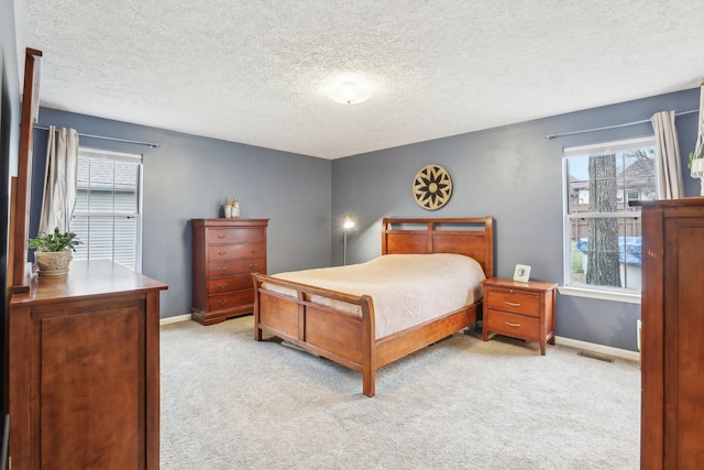 bedroom featuring light carpet and a textured ceiling