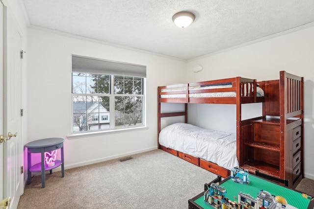 carpeted bedroom featuring ornamental molding and a textured ceiling