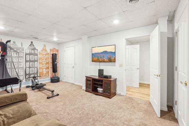 workout room featuring carpet and a drop ceiling