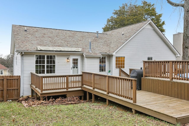 back of house with a wooden deck and a lawn