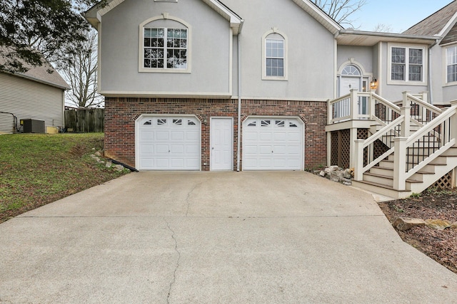 bi-level home with central AC unit and a garage