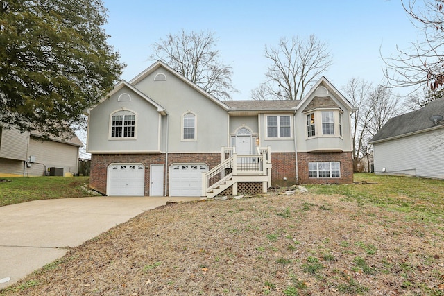 split foyer home with a garage, a front lawn, and central air condition unit