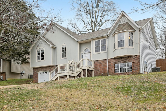 raised ranch featuring cooling unit, a garage, and a front yard