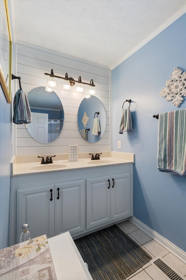 bathroom featuring ornamental molding, vanity, tile patterned flooring, and a textured ceiling