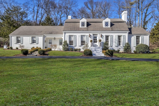 cape cod home featuring a front lawn