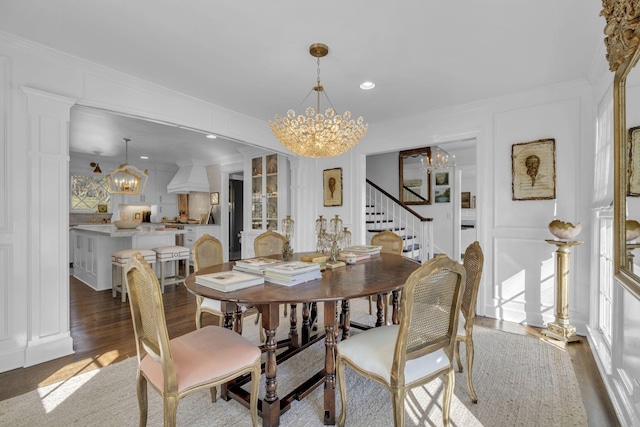 dining room with a notable chandelier, ornamental molding, and dark hardwood / wood-style floors