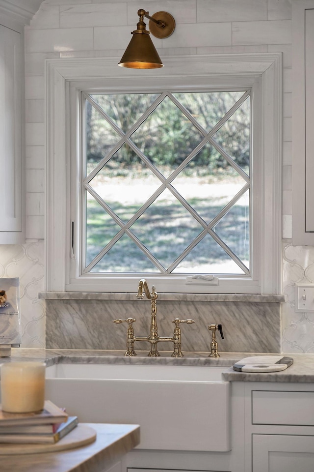 details with white cabinetry, sink, and backsplash