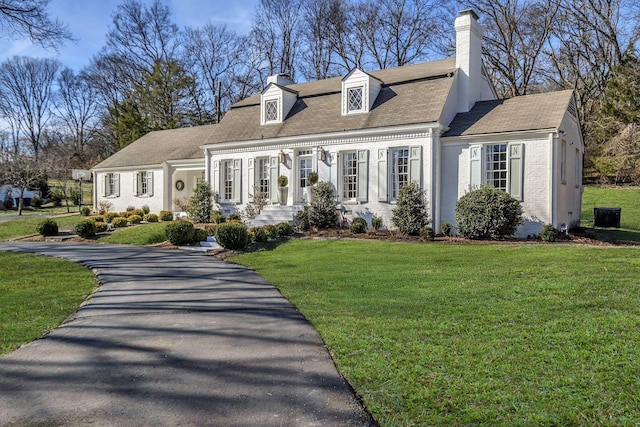 cape cod house with a front lawn