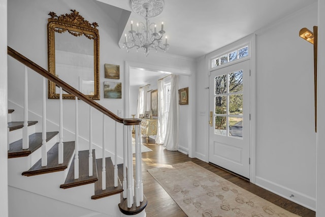 foyer featuring a notable chandelier, hardwood / wood-style flooring, and ornamental molding