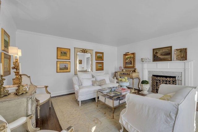 living room featuring ornamental molding, a fireplace, and light hardwood / wood-style flooring