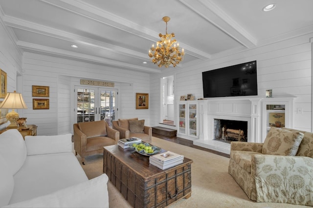 living room featuring a premium fireplace, beam ceiling, wooden walls, french doors, and a chandelier