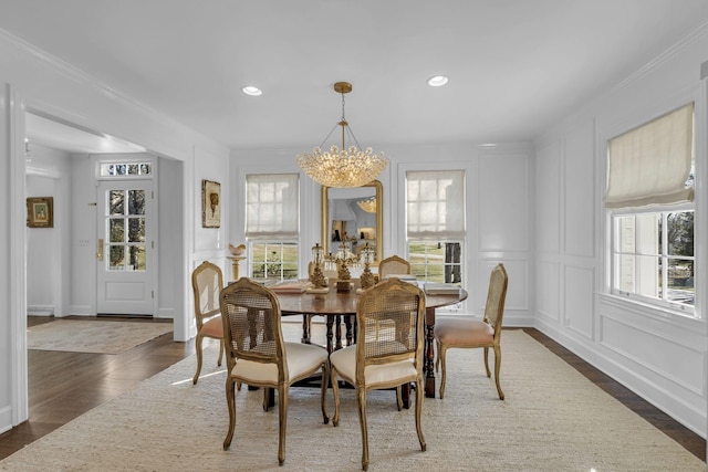 dining space with an inviting chandelier, ornamental molding, and dark hardwood / wood-style flooring