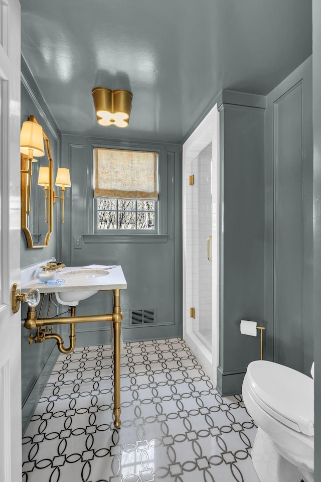 bathroom featuring tile patterned floors, toilet, and an enclosed shower