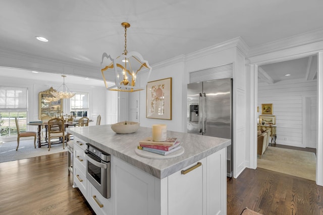 kitchen featuring white cabinetry, decorative light fixtures, a chandelier, and appliances with stainless steel finishes