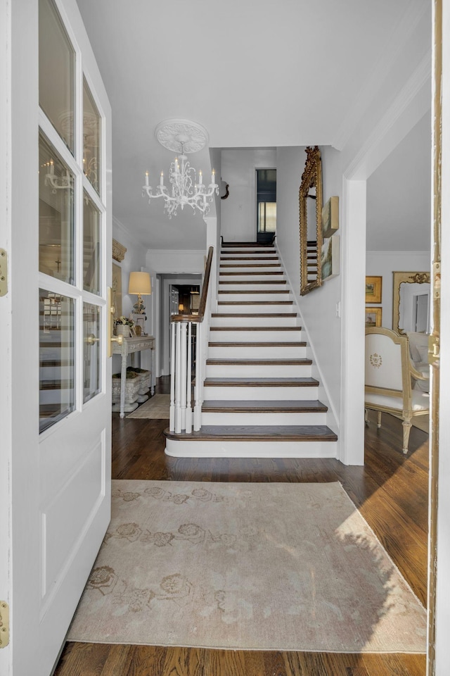 staircase featuring an inviting chandelier and hardwood / wood-style floors