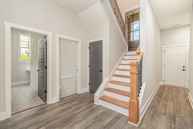 stairs with visible vents, baseboards, and wood finished floors