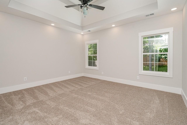 unfurnished room featuring carpet, recessed lighting, a raised ceiling, visible vents, and baseboards