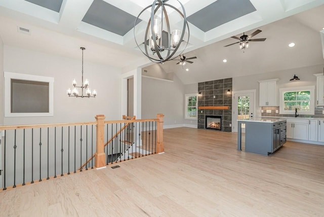 kitchen with open floor plan, a center island, light countertops, light wood-style floors, and white cabinetry