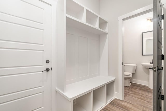 mudroom featuring light wood finished floors and baseboards