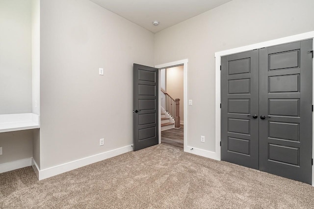 unfurnished bedroom featuring a closet, carpet, and baseboards