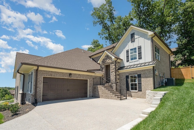 view of front of home featuring central AC unit, concrete driveway, fence, board and batten siding, and brick siding