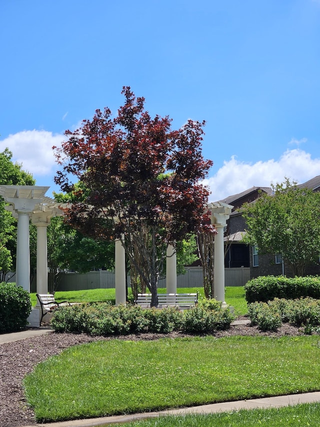 surrounding community featuring a pergola, fence, and a lawn