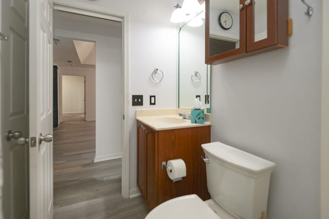 bathroom featuring vanity, wood-type flooring, and toilet