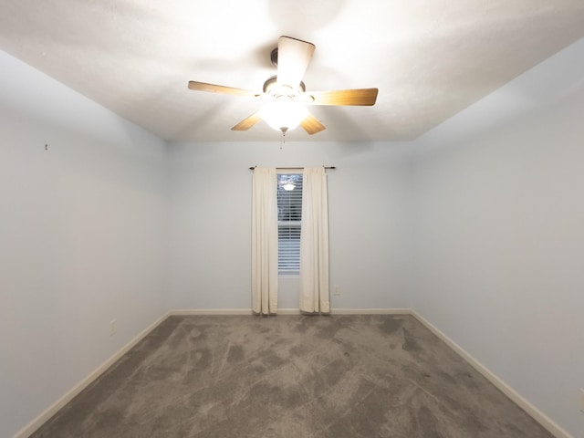 spare room with dark carpet and ceiling fan