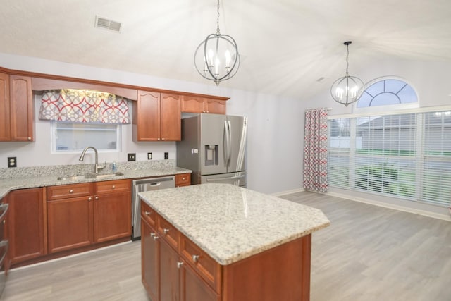 kitchen with pendant lighting, stainless steel appliances, sink, and a notable chandelier