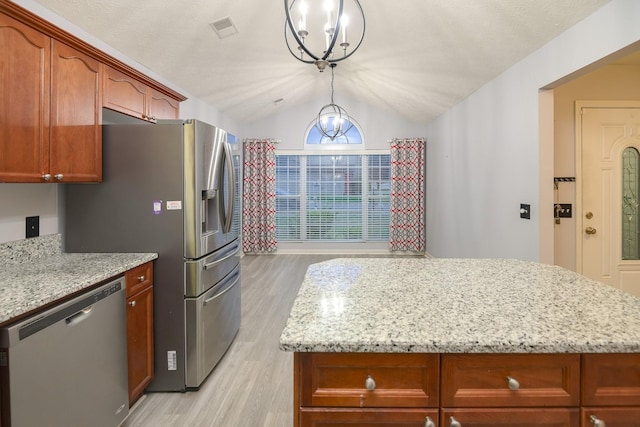 kitchen with decorative light fixtures, lofted ceiling, stainless steel dishwasher, light stone countertops, and light hardwood / wood-style flooring