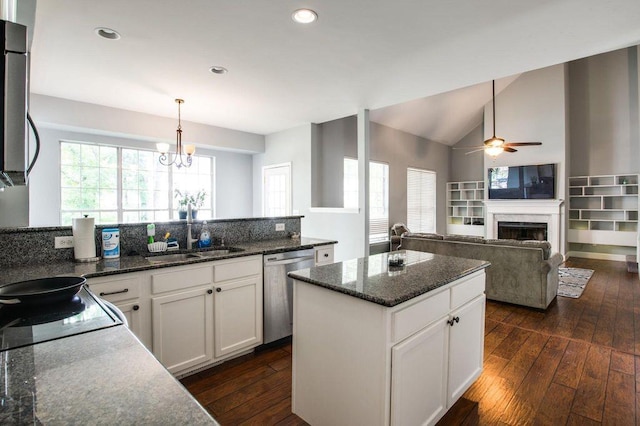 kitchen with sink, a center island, dark stone countertops, stainless steel dishwasher, and white cabinets