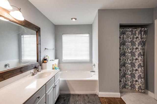 bathroom featuring tile patterned flooring, vanity, and a washtub