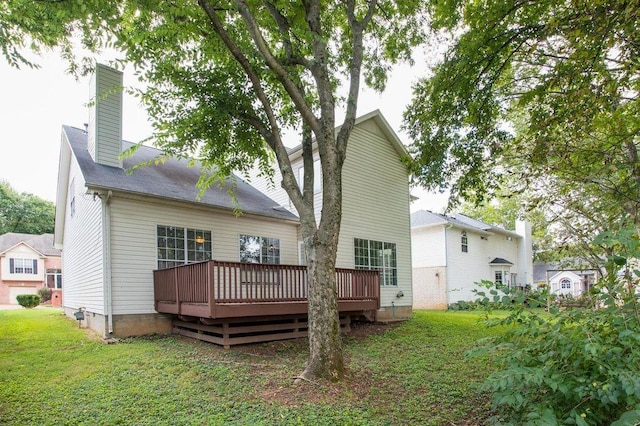 rear view of house featuring a yard and a deck