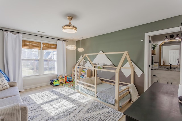 bedroom featuring sink and light wood-type flooring