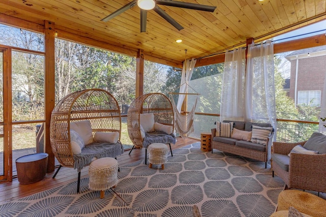 sunroom / solarium featuring plenty of natural light, wooden ceiling, ceiling fan, and vaulted ceiling