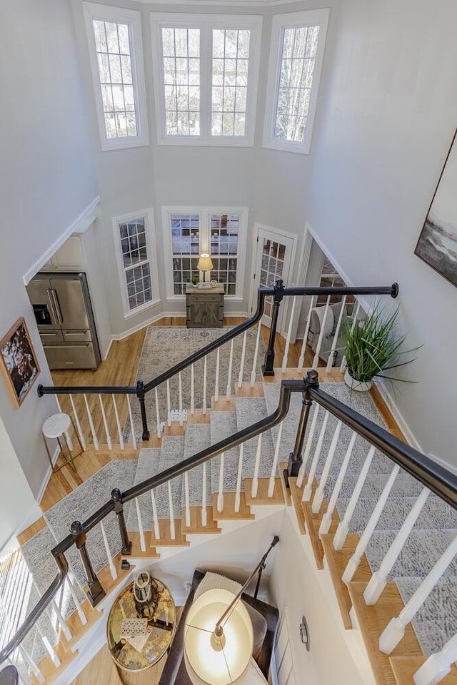 stairway featuring hardwood / wood-style flooring and a high ceiling