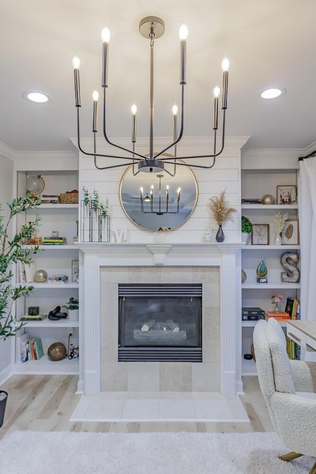 details with built in shelves, ornamental molding, a fireplace, and wood-type flooring