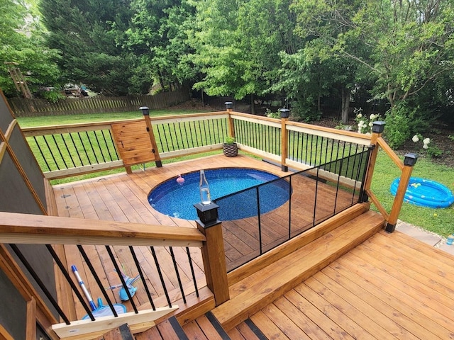 view of swimming pool featuring a lawn and a deck