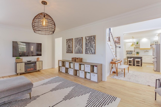 living room with crown molding and light hardwood / wood-style floors