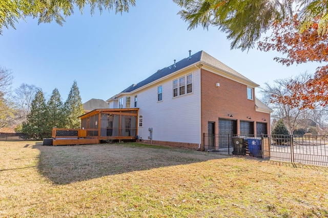 rear view of house featuring a garage, a sunroom, a yard, and a deck