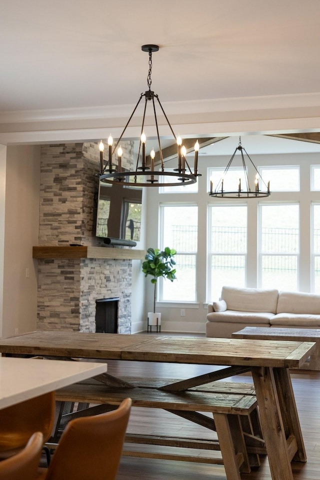 unfurnished dining area with crown molding, a fireplace, and wood finished floors