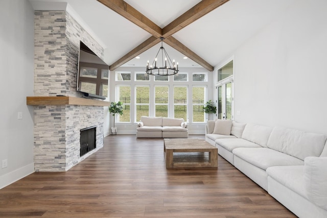 unfurnished living room with a stone fireplace, a notable chandelier, wood finished floors, baseboards, and beam ceiling